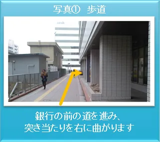 道順写真1：駅北口から銀行前の歩道を進む視点の写真（通行人が写る場合は後ろ姿）